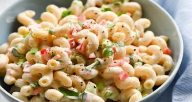 Imagen terminada de Sopa de coditos fría en plato hondo con hielo y decoración de cilantro fresco.