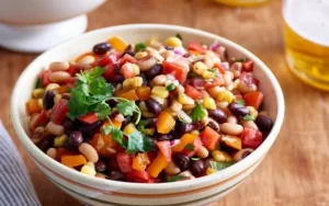 Imagen de una colorida ensalada de frijoles mixtos con variedad de vegetales frescos y aderezo agridulce