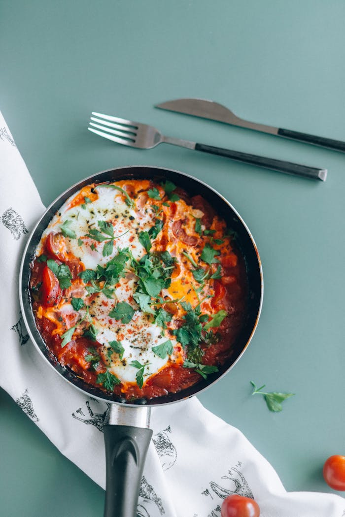 services-02 Delicious shakshuka in a pan garnished with fresh parsley, perfect for a healthy meal.